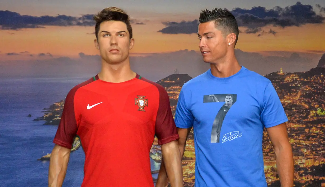 Cristiano Ronaldo dan patung lilin dirinya di Museum CR7 di Funchal, Madeira, Portugal (23/7). Museum tersebut berisi perjalanan karier Ronaldo selama bertahun-tahun menggeluti dunia lapangan hijau. (AFP PHOTO/Helder Santos)