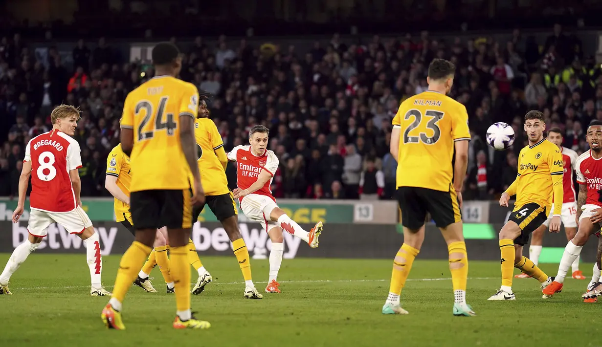 Gelandang Arsenal, Leandro Trossard (tengah) melepaskan tendangan yang menghasilkan gol pertama timnya ke gawang Wolverhampton Wanderers pada laga pekan ke-33 Premier League 2023/2024 di Molineux Stadium, Wolverhampton, Sabtu (20/4/2024). (PA via AP Photo/Mike Egerton)