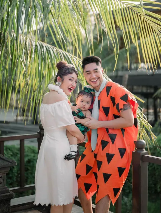 Potret bahagia keluarga Sibad bersama sang buah hati. Pada momen tersebut, Krisjiana berdandan mengenakan kostum Fred. Sedangkan Sibad menjadi Wilma Flinstone, istri Fred.  [Instagram/krisjianabah]