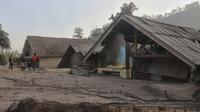 Penduduk desa memeriksa kerusakan saat rumah terlihat terkubur abu vulkanik dari letusan Gunung Semeru di desa Kajar Kuning di Lumajang, Jawa Timur, Indonesia, Senin, 5 Desember 2022. Gunung berapi tertinggi di Indonesia pada hari ini Senin (5/12/2022), masih mengeluarkan awan panas guguran dengan amplitudo 25 mm dan lama gempa 386 detik. (AP Photo/Imanuel Yoga)