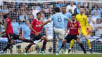 Pemain Manchester City, Ilkay Gundongan (tengah), menendang bola ke gawang Manchester United  yang membuahkan gol kedua dalam pertandingan final FA Cup 2022/2023 yang berlangsung di Wembley Stadium, Sabtu (3/6/2023). (AP Photo/Dave Thompson)