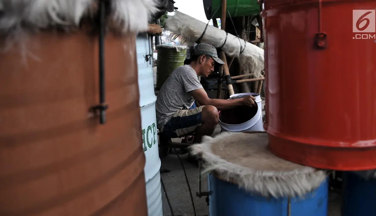 Pemandangan saat pengrajin menghaluskan drum untuk membuat beduk di kawasan Tanah Abang, Jakarta, Senin (14/5). Besaran harga tergantung ukuran dan jenis kulit yang digunakan. (Merdeka.com/Iqbal Nugroho)