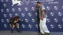 Timothee Chalamet (kiri) membungkuk di depan sutradara Luca Guadagnino (kanan) saat mereka berpose dengan Taylor Russell pada sesi pemotretan untuk film 'Bones and All' selama Venice Film Festival 2022 ke-79 di Venesia, Italia (2/9/2022). (Photo by Joel C Ryan/Invision/AP)