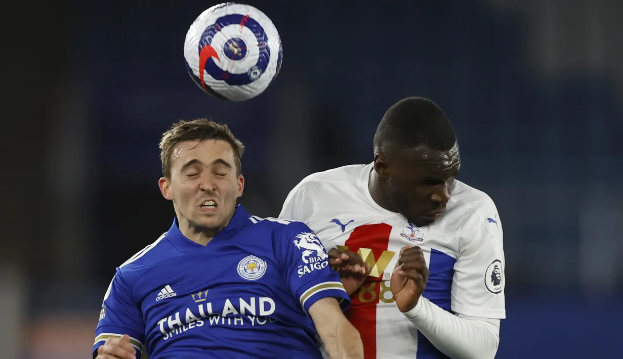 Bek Leicester City, Timothy Castagne (kiri) berduel udara dengan striker Crystal Palace, Christian Benteke dalam laga lanjutan Liga Inggris 2020/2021 pekan ke-33 di King Power Stadium, Leicester, Senin (26/4/2021). Leicester menang 2-1 atas Crystal Palace. (AP/Adrian Dennis/Pool)
