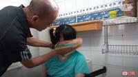 Seorang ayah merawat putrinya yang menderita disabilitas intelektual karena istrinya dirawat di rumah sakit akibat Covid-19 (dok. Youtube/Tzu Chi Singapore)