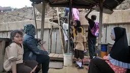 Warga menaiki perahu saat hendak menyeberang ke Kampung Pulo dari Bukit Duri, Jakarta, Rabu (28/12). Meski penumpang tak seramai dulu, perahu eretan tetap bertahan diantara tembok beton normalisasi kali Ciliwung. (Liputan6.com/Yoppy Renato)
