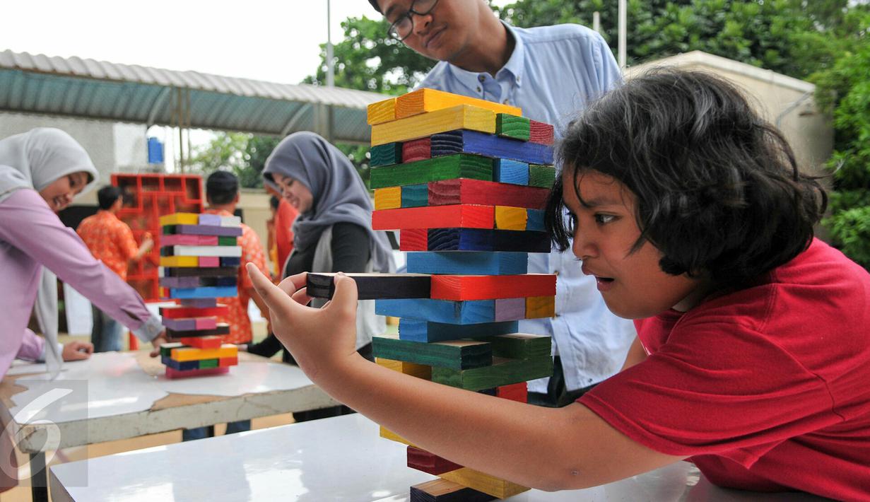 Seorang anak antusias saat melakukan permainan menyusun balok di acara tahunan Sekolah Cikal Amri, Cipayung, Jakarta Timur, Jumat (18/12). Berbagai kegiatan menarik diadakan dalam acara tahunan ini. (Liputan6.com/Yoppy Renato)