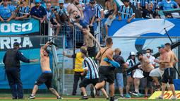 Selain itu para suporter yang mengamuk itu juga tanpa ragu menyerang petugas keamanan yang berjaga di lapangan. Mereka melempari petugas dengan botol dan batu. Aksi baku hantam pun tidak dapat dihindari. (AFP/Raul Pereira)