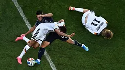 Pemain Jerman Jamal Musiala berebut bola dengan pemain Paraguay Braian Ojeda, sementara pemain Jerman, Nick Woltemade tergeletak di tanah selama pertandingan sepak bola babak 32 besar Piala Dunia 2026 antara Jerman dan Paraguay di Stadion Boston di Foxborough, AS, Senin (29/06/2026). AFP/ Jewel Samad