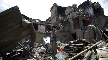 Seorang pria berdiri di puing-puing bangunan setelah gempa susulan berkekuatan 7,3 SR melanda Sankhu, Nepal, Selasa (12/5/2015). Sebelumnya, luka atas gempa dahsyat yang terjadi 25 April lalu di Nepal masih belum terobati. (REUTERS/Navesh Chitrakar)