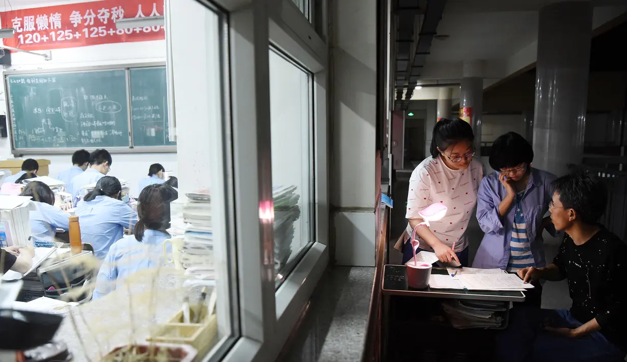 Guru berjaga saat para siswa mengerjakan soal menjelang ujian tahunan "Gaokao" atau ujian masuk perguruan tinggi di China, di Handan di provinsi Hebei Utara (23/5). Gaokao China akan berlangsung 7-8 Juni tahun ini. (AFP Photo/China Out)