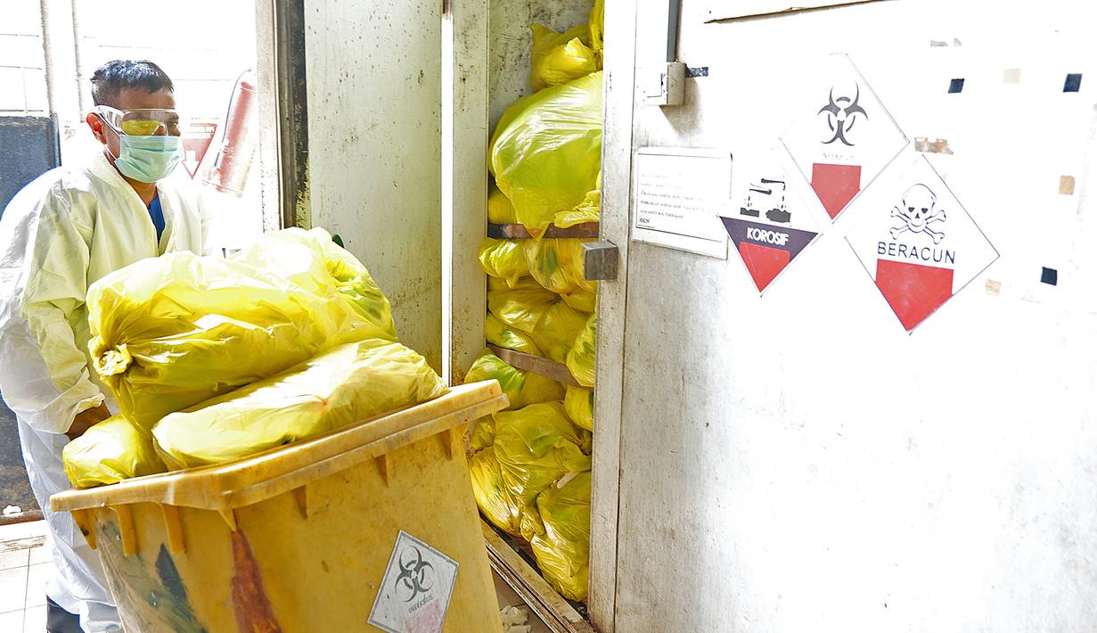 Petugas mengambil limbah medis di TPS untuk proses pembakaran ke incinerator di RSCM Jakarta, Jumat (26/6/2020). Menteri Lingkungan Hidup Siti Nurbaya Bakar menyebutkan volume limbah medis infeksius di seluruh Indonesia hingga 8 Juni 2020 mencapai lebih dari 1.100 ton. (Liputan6.com/Herman Zakharia)