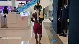 Anggota suku Kariri berjalan di sebuah mal di Brasilia (26/8/2021).  Ia masuk ke dalam mal saat para pengunjuk rasa suku pribumi lainnya berkumpul di ibu kota Brasil saat Mahkamah Agung bersiap untuk menangani kasus yang dapat menghilangkan keberatan di tanah leluhur mereka. (AFP/Carl De Souza)