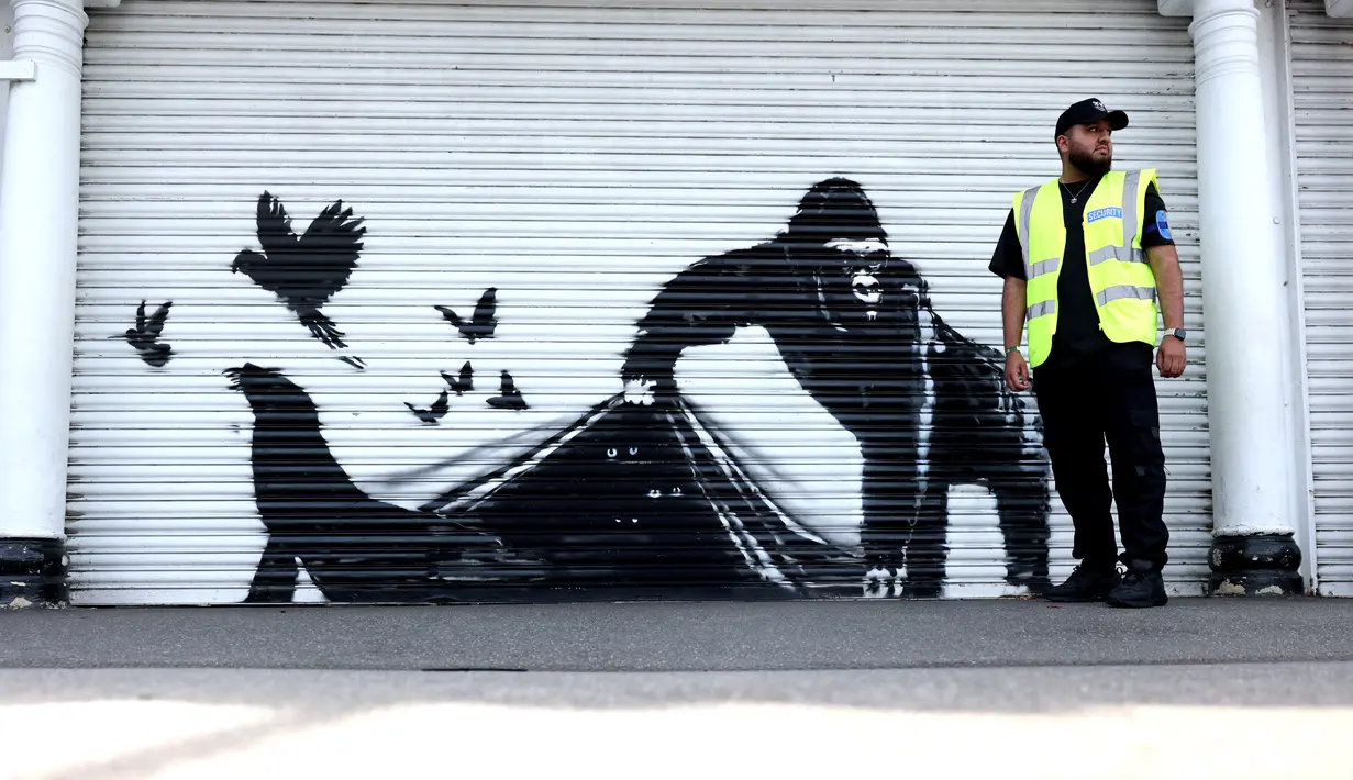 Sebuah karya seni oleh seniman jalanan Banksy, yang kesembilan yang dirilis dalam sembilan hari, menggambarkan seekor gorila yang sedang melepaskan hewan, di bagian depan rana di luar kebun binatang London, pada 13 Agustus 2024. (Adrian DENNIS / AFP)