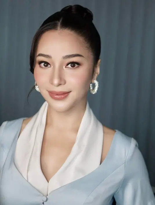 Bagian kelopak matanya diberikan eyeshadow coklat tipis, aplikasi bronzer di wajahnya memberi rona hangat. Sementara untuk pipi dan bibirnya, dipilih rona kombinasi coral dan pink yang dapat memberi impresi wajah segar. [@evalovira].