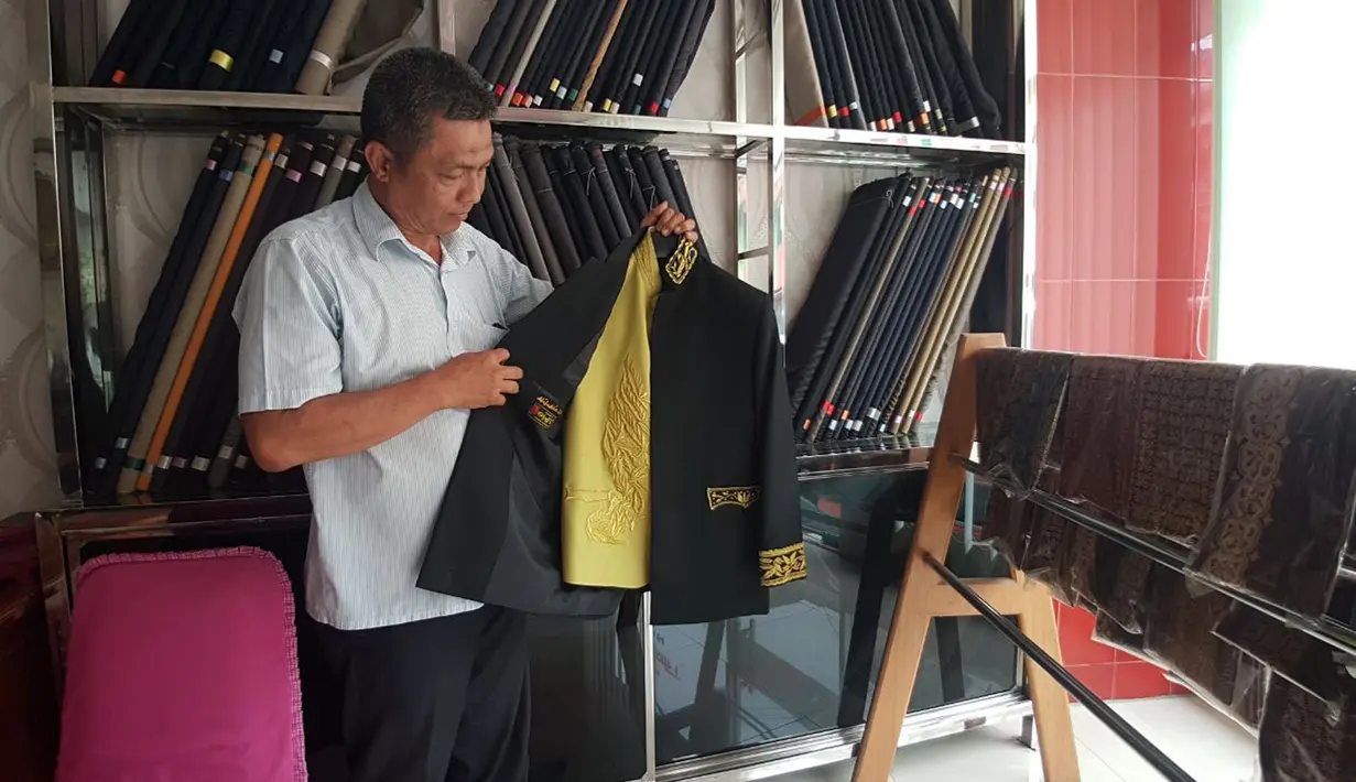 Pekerja menunjukkan pakaian yang akan dikenakan para Raja Adat saat ngunduh mantu Kahiyang-Bobby di Medan, Kamis (23/11). Sebanyak 41 busana adat lengkap telah dipersiapkan untuk acara ngunduh mantu Kahiyang-Bobby. (Liputan6.com/Aditya Eka)