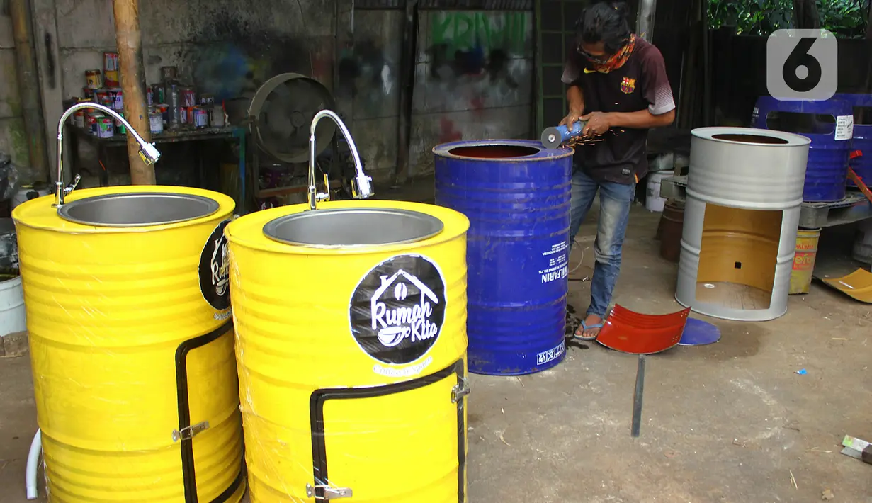 Perajin memproduksi wastafel portabel berbahan baku drum di workshop Galuh Creatives, Tangerang Selatan, Sabtu (30/5/2020). Wacana pemerintah menerapkan tatanan normal baru berimbas pada meningkatnya pesanan wastafel portabel untuk kebutuhan masyarakat di wilayah Jabotabek. (merdeka.com/Arie Basuki)