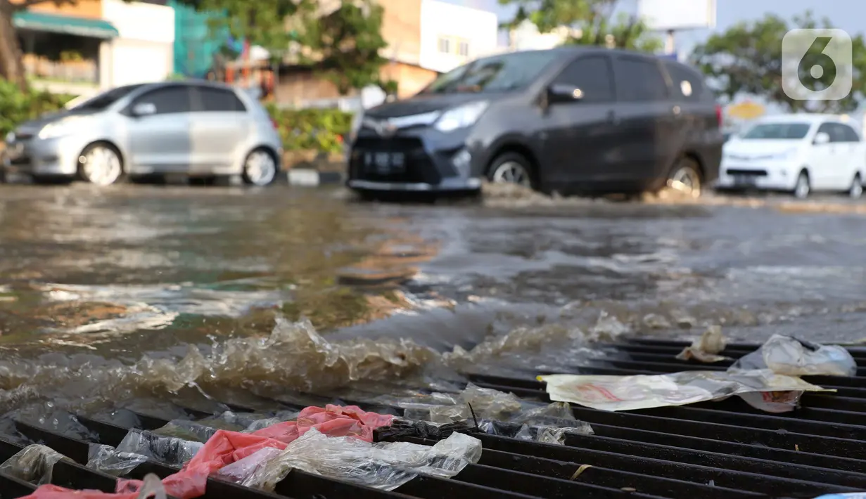 Ceceran sampah tersangkut di penutup saluran air di jalan Margonda Raya yang tergenang air, Kota Depok, Jawa Barat, Jumat (29/5/2020). Tersumbatnya aliran air menyebabkan sebagian ruas jalan Margonda Raya sempat tergenang air serta menyebabkan lalu lintas tersendat. (LIputan6.com/Helmi Fithriansyah)