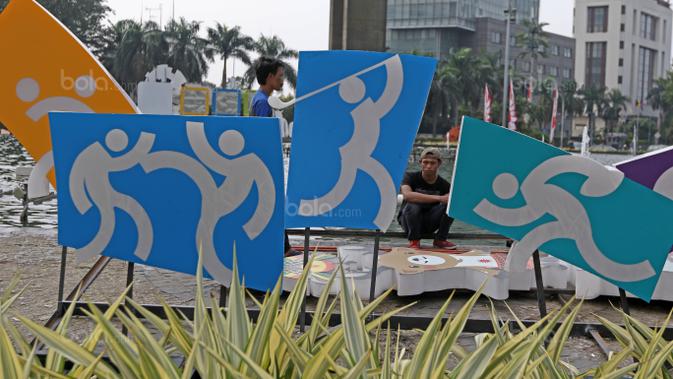 Pekerja menanti giliran memasang logo Asian Games 2018 di Bundaran HI, Jakarta, (17/8/2017), Asian Games mengambil tema Energy Of Asia dan akan dibuka oleh Presiden Republik Indonesia Joko Widodo. (Bola.com/Nicklas Hanoatubun)