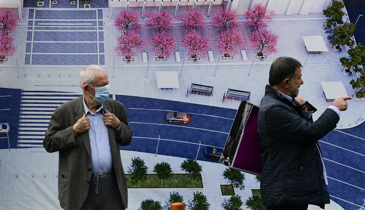 Seorang pria bermasker berdiri di Syntagma square, Athena, Selasa (9/11/2021). Yunani melaporkan rekor tertinggi baru kasus COVID-19 harian pada Senin ketika janji vaksinasi melonjak setelah pembatasan baru untuk yang tidak divaksinasi diberlakukan selama akhir pekan. (AP Photo/Michael Varaklas)