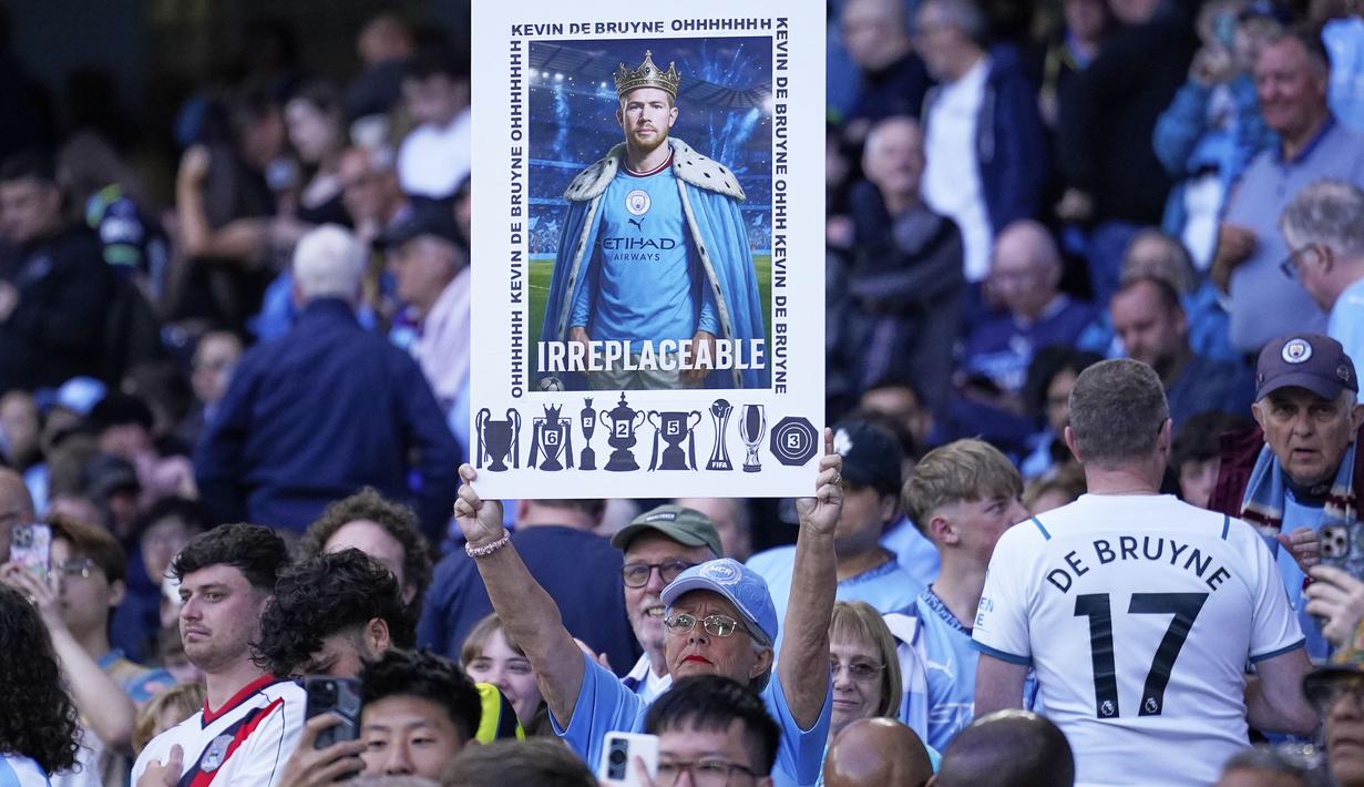 Pendukung Manchester City mengangkat poster bertuliskan "Tak Tergantikan" untuk perpisahan Kevin De Bruyne saat laga pekan ke-37 Liga Inggris 2024/2025 melawan Bournemouth di Etihad Stadium, Manchester, Inggris, Selasa (21/05/2025) waktu setempat. (AP Photo/Dave Thompson)