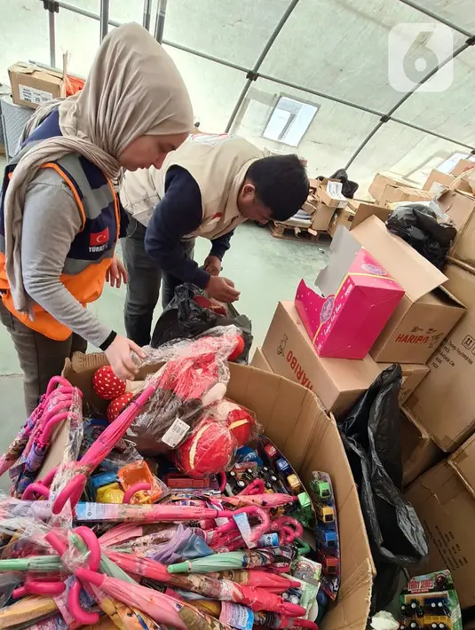 Petugas organisasi kemanusiaan memeriksa bantuan mainan anak dari Bulan Sabit Merah Indonesia (BSMI) di pengungsian Taman Ataturk, Kahramansan, Turki, Selasa (21/2/2023). Juru Bicara BSMI Hafidz Muftisany mengatakan, bantuan berupa mainan anak ini diharapkan dapat membantu memulihkan trauma para korban, khususnya anak-anak, pascagempa. (Liputan6.com/Andry Haryanto)