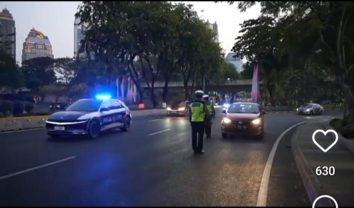 Di lokasi nampak sejumlah personel polisi berjaga-jaga. Sebuah mobil berwarna merah yang hendak masuk ke jalur iring-iringan pun ditepikan oleh petugas.<br>