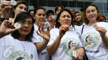 Sejumlah pendukung Mirna memperlihatkan pin bergambar wajah Mirna yang tengah tersenyum jelang sidang vonis di PN Jakarta Pusat, Kamis (27/10). Para pendukung Mirna berharap terdakwa Jesicca Wongso divonis mati. (Liputan6.com/Helmi Afandi)