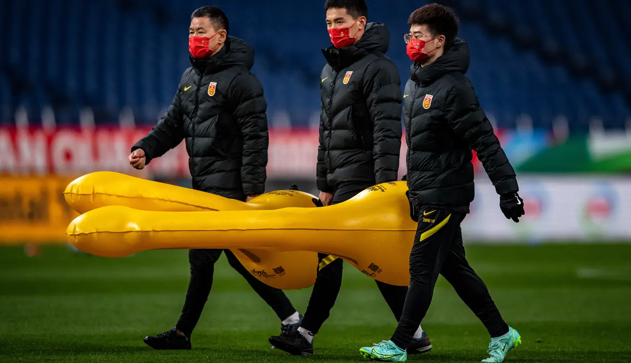 Anggota staf tim China menghadiri sesi latihan di Stadion Saitama, Jepang, Rabu (26/1/2022). China butuh 3 angka di laga ini. Wu Lei dan kawan-kawan masih ada di urutan 5 klasemen Grup B dengan raihan 5 poin. (AFP/Philip Fong)