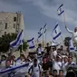 Warga Israel mengibarkan bendera nasional selama pawai&nbsp;peringatan&nbsp;Hari Yerusalem di luar Kota Tua Yerusalem pada Kamis (18/5/2023). (Dok. AP/Maya Alleruzzo)