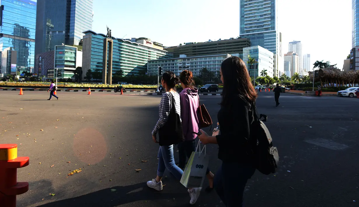 Pekerja kantoran swasta berjalan kaki di Jalan MH Thamrin, Jakarta Pusat, Jumat (24/5/2019). Jalan MH Thamrin masih ditutup karena dikhawatirkan masih ada aksi susulan usai kerusuhan 22 Mei 2019. (merdeka.com/Imam Buhori)