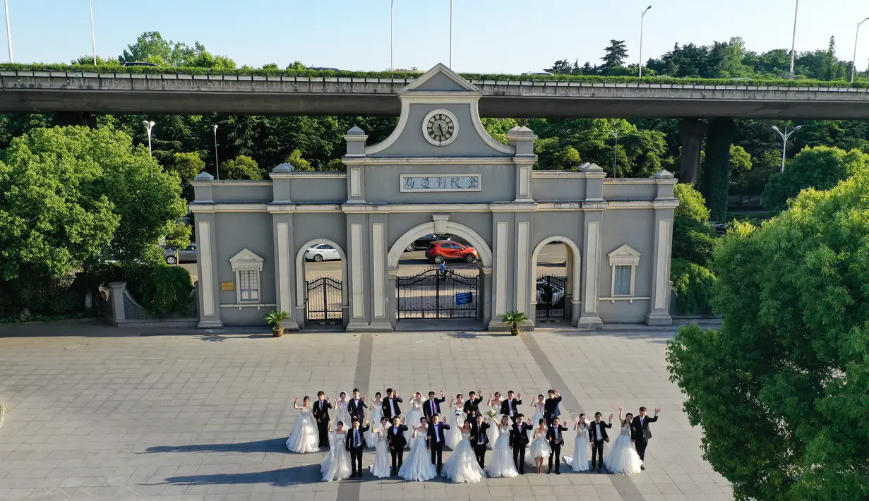 Para pasangan pengantin berpose bersama di Nanjing, Provinsi Jiangsu, China timur, pada 19 Mei 2020. Sebanyak 15 pasangan pengantin pada Selasa (19/5) berfoto bersama di Nanjing menjelang upacara pernikahan massal mereka yang dihelat pada 20 Mei. (Xinhua/Ji Chunpeng)