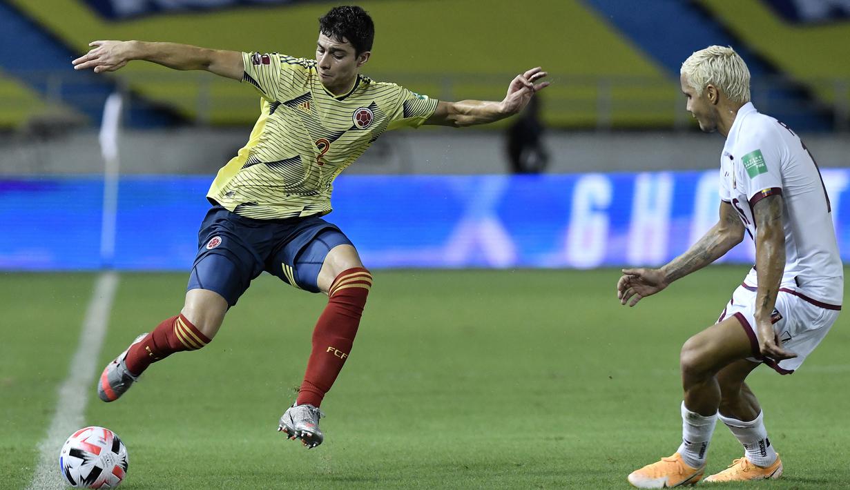 Bek Kolombia, Stefan Medina, berebut bola dengan bek Venezuela, Roberto Rosales, pada laga kualifikasi Piala Dunia 2022 zona Amerika Selatan di Estadio Metropolitano, Sabtu (10/10/2020) pagi WIB. Kolombia menang 3-0 atas Venezuela. (AFP/Gabriel Aponte/pool)