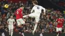Pemain Leeds United, Patrick Bamford, menendang pemain Manchester United, Lisandro Martinez pada laga Liga Inggris di Stadion Old Trafford, Rabu (8/2/2023). Kedua tim bermain sama kuat dengan skor 2-2. (AP Photo/Dave Thompson)