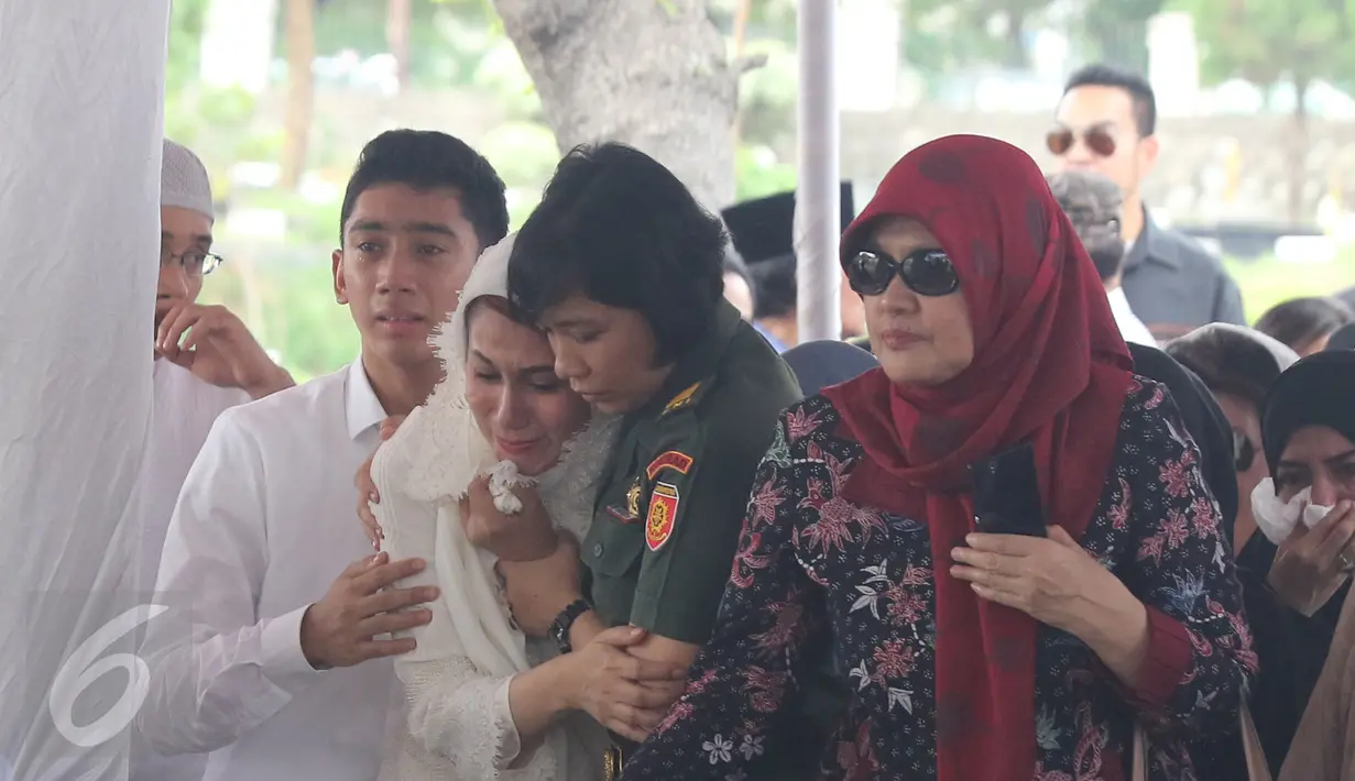 Tangis Marini Zumarnis saat prosesi pemakaman ayahnya, Zumarnis Zein, di TPU Karet Bivak, Jakarta, Jumat (17/6). Prosesi pemakaman ayah Marini Zumarnis dilakukan secara militer, diiringi bunyi tembakan. (Liputan6.com/Herman Zakharia)