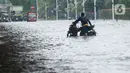 Pengendara mendorong sepeda motor mereka saat melewati banjir yang merendam Jalan Ahmad Yani, Jakarta, Sabtu (8/2/2020). Hujan yang mengguyur Jakarta sejak semalam membuat sejumlah ruas jalan terendam banjir. (merdeka.com/Imam Buhori)