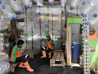 Petugas UPK Badan Air DLH DKI Jakarta bersantai dalam Pos Botol Plastik di Pasar Rebo, Jakarta, Selasa (12/3). Petugas memanfaatkan botol plastik bekas untuk membangun pos cantik. (merdeka.com/Iqbal Nugroho)