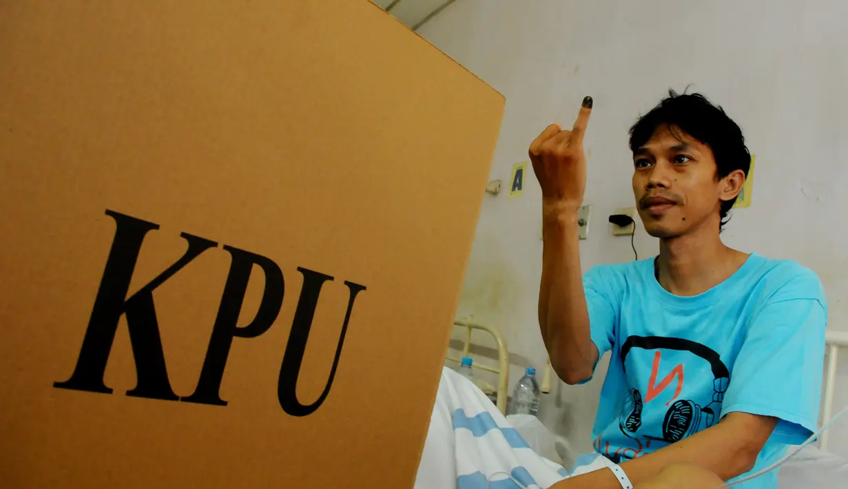 Seorang pasien menunjukkan jari kelingkingnya seusai menggunakan hak pilihnya di RS.Fatmawati, Jakarta Selatan, Rabu (9/4) (Liputan6.com/Andrian M Tunay)