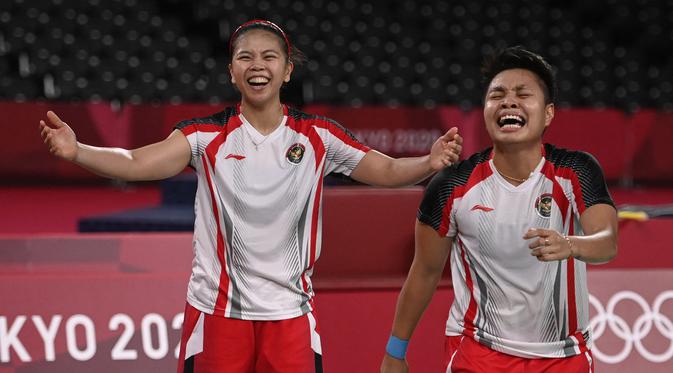 Pasangan Indonesia, Apriyani Rahayu dan Greysia Polii (kiri) merayakan kemenangan setelah pertandingan final bulu tangkis ganda putri melawan Jia Yifan dan Chen Qingchen dari China selama Olimpiade Tokyo 2020 di Musashino Forest Sports Plaza di Tokyo pada 2 Agustus 2021. (AFP/Alexander Nemenov)