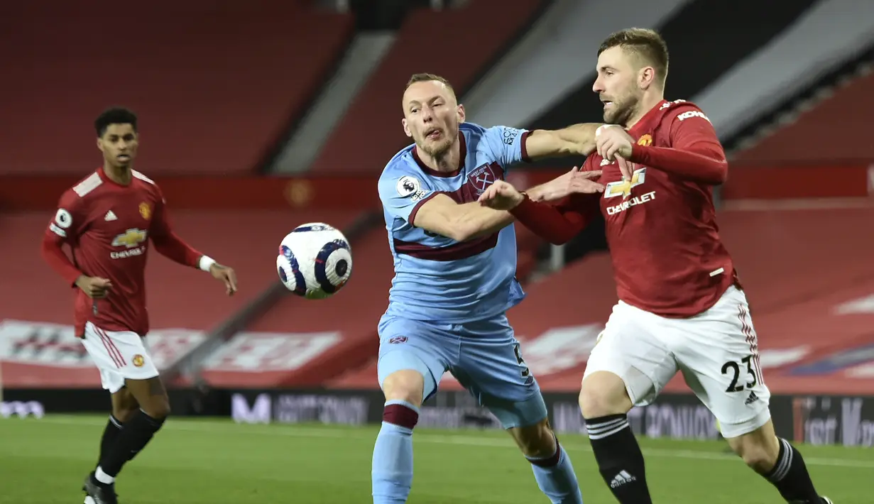 Bek West Ham, Vladimir Coufal dan bek Manchester United, Luke Shaw bersaing memperebutkan bola pada pekan 29 Liga Inggris 2020-2021 di Old Trafford, Senin dinihari WIB (15/3/2021). Manchester United atau MU berhasil mencuri poin penuh usai kalahkan West Ham 1-0. (AP Photo/Clive Brunskill,Pool)