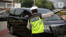 Petugas polisi mengarahkan kendaraan berplat nomor ganjil di titik pemeriksaan ganjil-genap Bundaran Senayan, Jakarta, Kamis, (26/8/2021). Mulai 26 sampai 30 Agustus, ganjil genap hanya berlaku di 3 ruas jalan Jakarta yakni, Jalan Sudirman, MH Thamrin, dan HR Rasuna Said (Liputan6.com/Faizal Fanani)