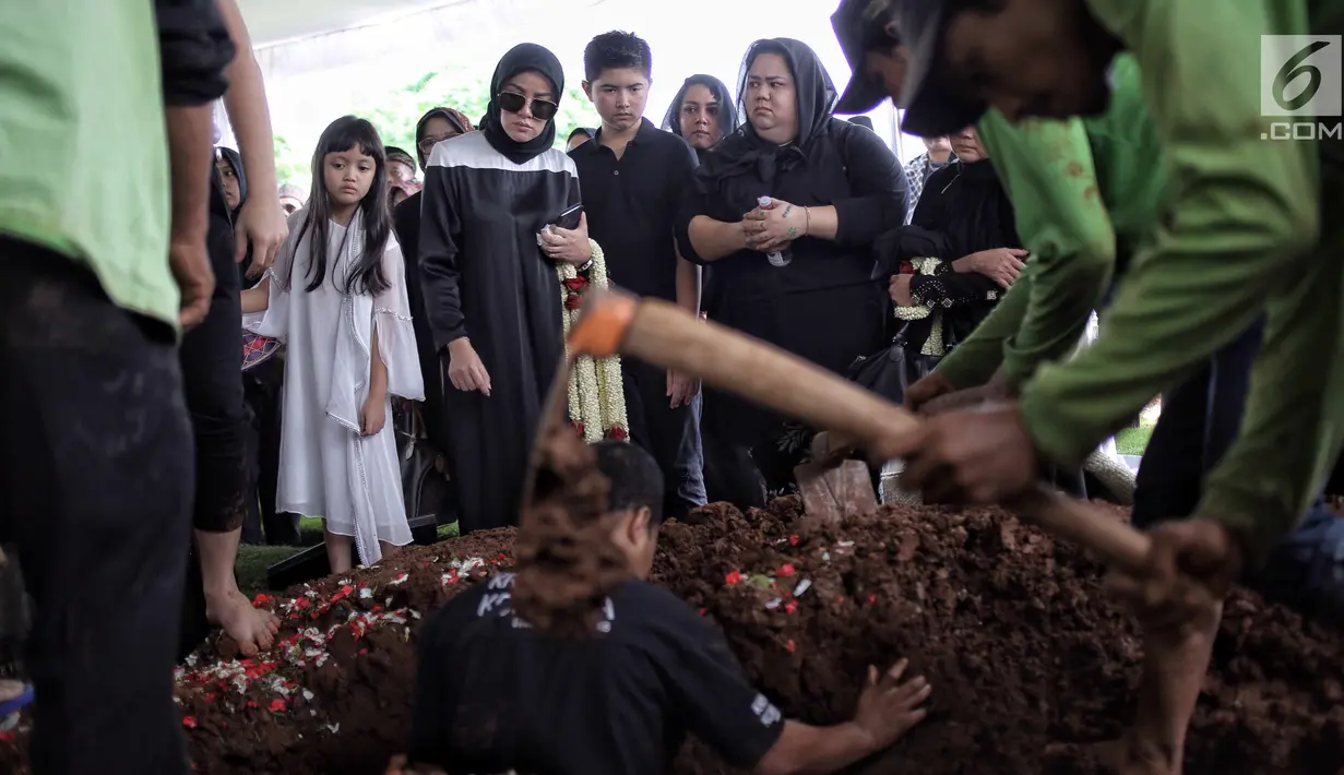 Aktris Olla Ramlan menyaksikan proses pemakaman sang ayahanda, Muhammad Ramlan di TPU Tanah Kusir, Jakarta, Selasa (5/6). Ayahanda Olla Ramlan meninggal di usia 72 tahun akibat kanker dan liver yang dideritanya. (Liputan6.com/Faizal Fanani)