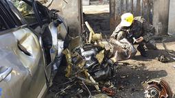 Personel militer memeriksa puing-puing dari tabrakan pesawat latih KT-1 Angkatan Udara Korea Selatan di sebuah desa di Sacheon, Korea Selatan, Jumat (1/4/2022). Dua pesawat angkatan udara Korea Selatan bertabrakan di udara selama pelatihan. (Kim Dong-min/Yonhap via AP)