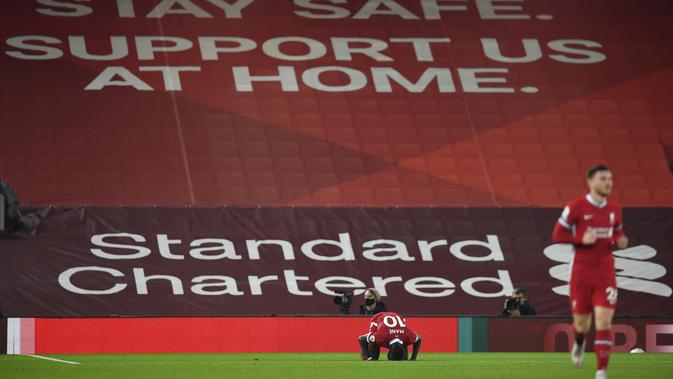 Pemain Liverpool Sadio Mane mencium lapangan saat ia merayakan gol pertama timnya selama pertandingan sepak bola Liga Premier Inggris antara Liverpool dan Arsenal di Anfield di Liverpool, Inggris, Senin, 28 September 2020. (Paul Ellis / Pool via AP)