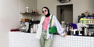 Strip kemeja warna biruyang dijadikan outer dipadu padankan dengan inner berwarna pink dan celana jeans. (instagram/tantrinamirah)