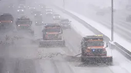 Pengemudi mengikuti kuartet bajak salju Negara Bagian Colorado di Interstate 25 di jalan layang Steele Street saat badai musim dingin yang membawa angin kencang dan salju lebat bergerak melintasi intermountain West di Denver (27/1/2022). (AP Photo/David Zalubowski)