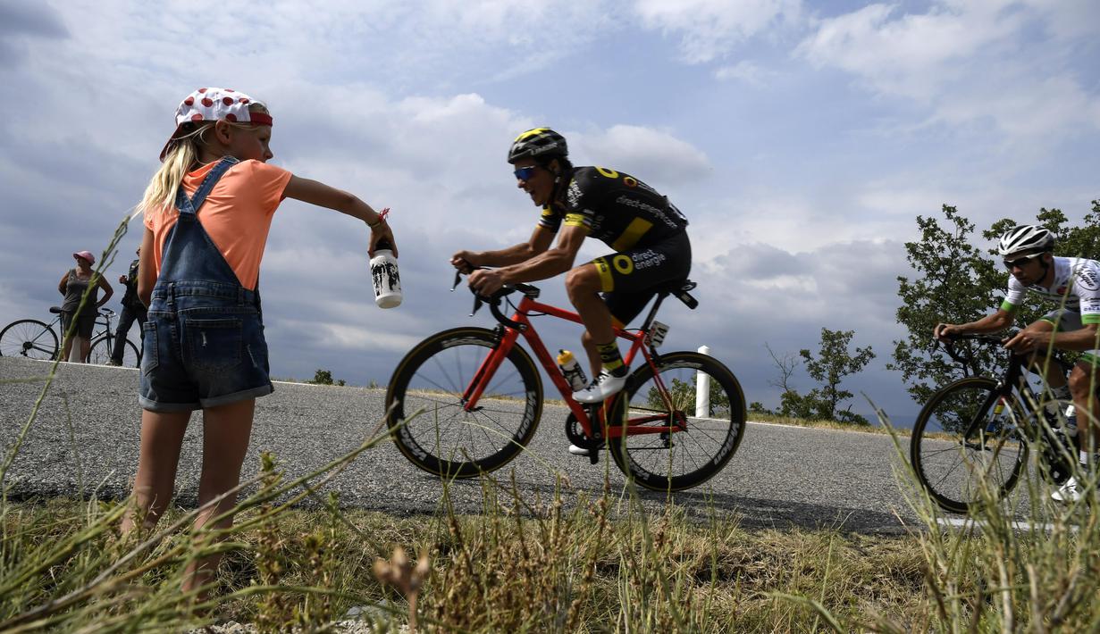 Seorang gadis kecil memberikan dukungan kepada pebalap Prancis, Sylvain Chavanel pada etape ke-19 Tour de France dengan  jarak tempuh 222,5 km dari Embrun menuju Salon-de-Provence, Prancis, (21/7/2017). (AFP/Jeff Pachoud)