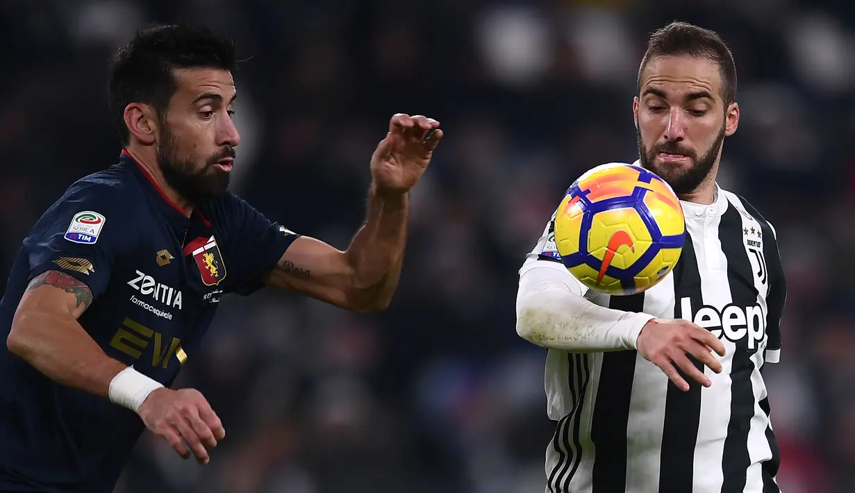 Bek Genoa, Nicolas Spolli berebut bola dengan pemain Juventus, Gonzalo Higuain dalam lanjutan pertandingan Serie A di Stadion Allianz, Turin, Senin (22/1). Juventus mengatasi perlawanan Genoa dengan skor 1-0. (MARCO BERTORELLO / AFP)