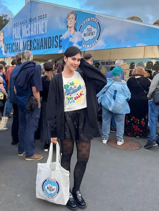 Syahnaz sempat berfoto di depan official merchandise Paul McCartney. Dia terlihat mengenakan kaos putih yang dipadukan dengan inner dan hot pants hitam