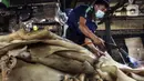 Pekerja membakar kulit sapi untuk dijadikan kerupuk di Kerupuk Kulit Bambang, Depok, Jawa Barat, Sabtu (28/8/2021). Pelaku usaha kerupuk kulit mengaku sejak Pemberlakuan Pembatasan Kegiatan Masyarakat (PPKM) produksi kerupuk kulit menurun hingga 60 persen. (Liputan6.com/Johan Tallo)
